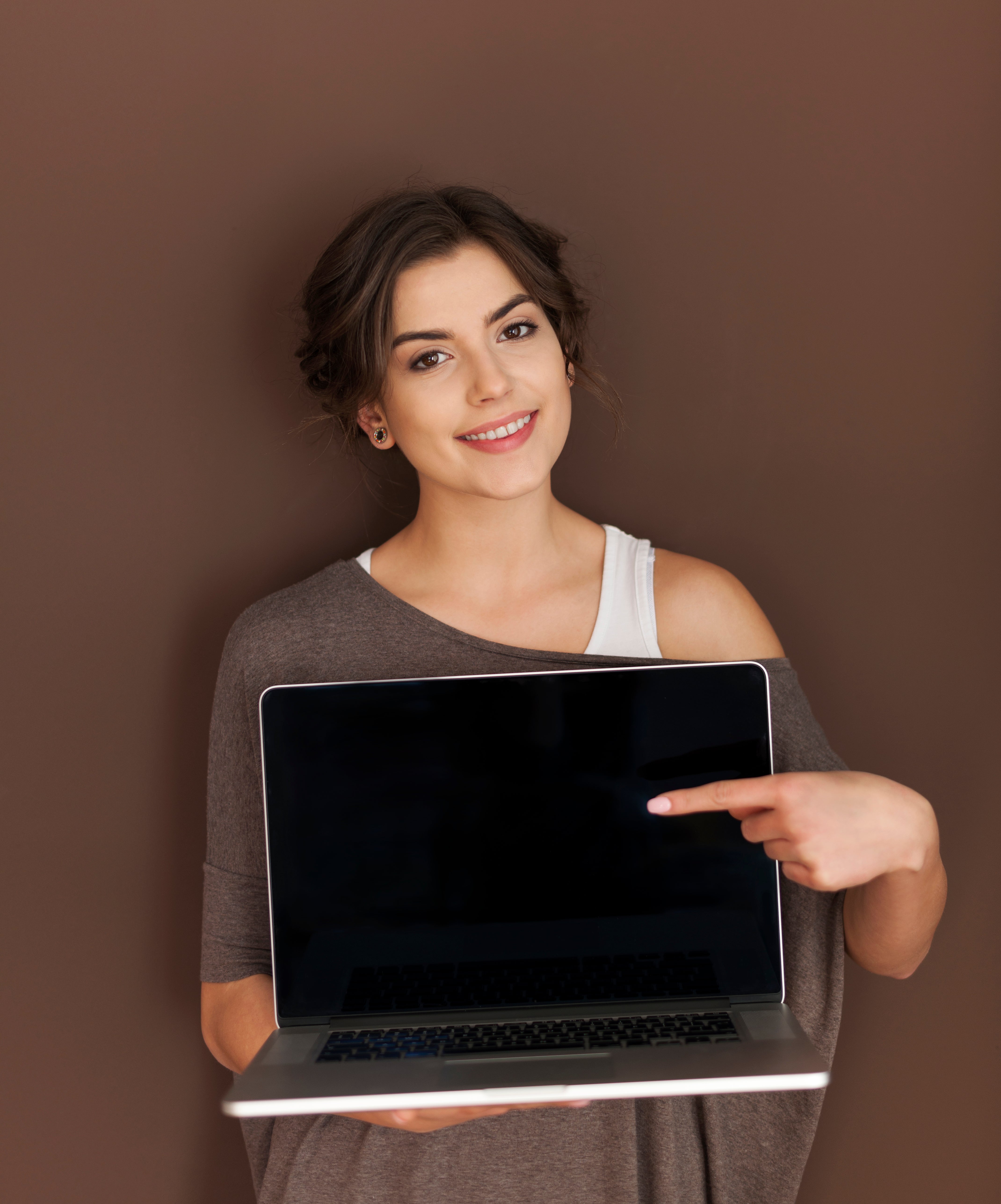 Smiling woman showing screen of contemporary laptop